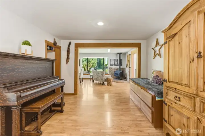 Room with piano and sitting space. Goes towards kitchen area