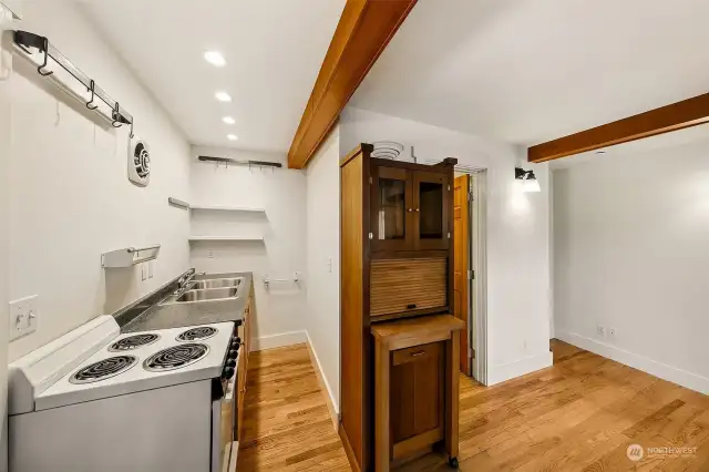 Apartment #7 - On the second floor with a small deck area, apartment 7 features oak floors, small kitchen, full bathroom and repurposed storage hutch from an area houseboat with built in garbage container, chopping block, and storage cabinet with glass doors. Follow the timber frame stairs up to the spacious sleeping loft.