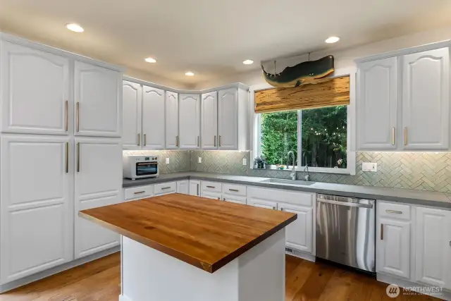 Kitchen was updated with paint, hardware, concrete counters and a full height tile backsplash. Shaw fireclay sink and Waterstone faucet