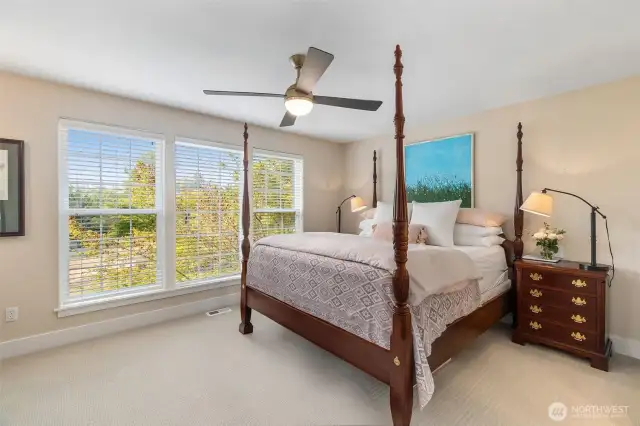 Primary bedroom with large windows at the front of the house for sunsets