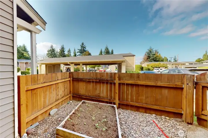 This sunny spot is fully fenced with raised garden beds—perfect for growing herbs and vegetables!