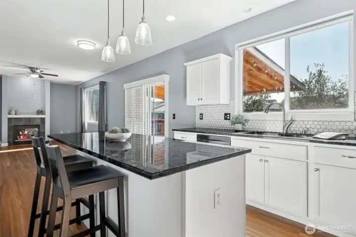 Cook's dream kitchen with large island with granite coutertops and walk-in pantry.
