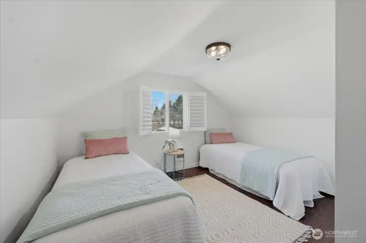 Upper level bedroom off of what's currently staged as home office area.  This room fits both a queen bed and or as pictured, two twins.  More space for additional closet space behind the door, though there is a closet in this room already