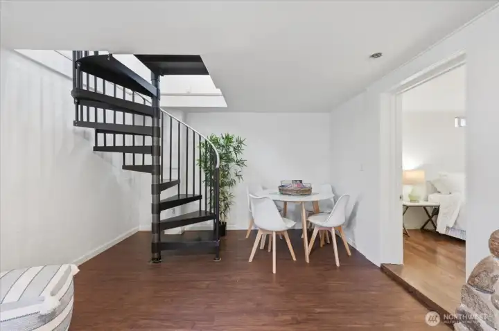 Showing how spiral staircase comes down into daylight basement with room under and around