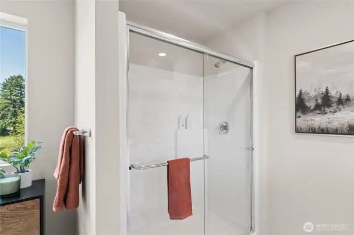 Step in shower with modern glass doors. Actual home is under construction and finishes, colors, and materials may vary. See site agent for details.