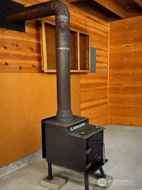 wood burning stove and paneled walls in workshop.