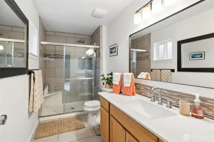 Tile flooring, floor to ceiling shower surround, large vanity with composite one piece top, new mirror, light fixtures, comfor height toilet and quality glass shower door complete this fantastic, quality upgrade. Tile flooring, floor to ceiling shower surround, large vanity with composite one piece top, new mirror, light fixtures, comfor height toilet and quality glass shower door complete this fantastic, quality upgrade.