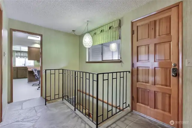 Slate entry with a "peekaboo view" of the kitchen. Stairway leads to the lower level.