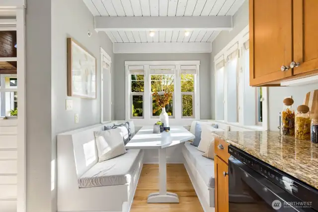 Eating area with booth-style seating and plenty of windows - cozy space to start your mornings