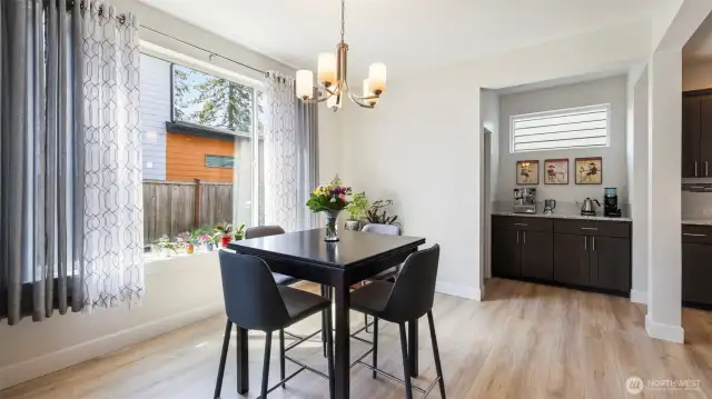 Dine in style: a bright, modern space with sleek black accents, cozy coffee nook, and plenty of natural light near the kitchen