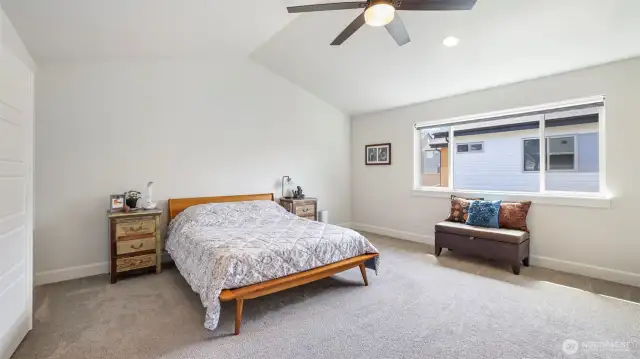 Broad primary suite with plenty of room for seating and stunning vaulted ceilings