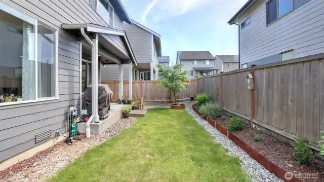 This fully fenced backyard offers plenty of planting space for gardening and is perfect for gatherings and BBQs