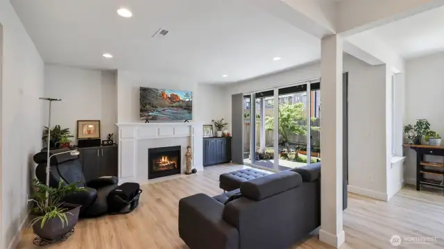 This seamless living space offers a perfect blend of comfort and light, with a fireplace and sliding doors that fill the space with sunshine and backyard views