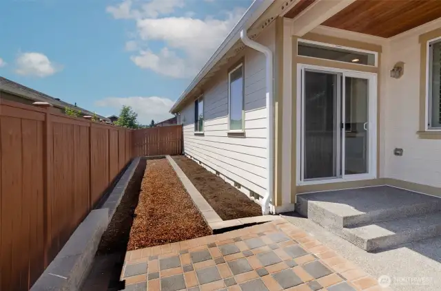 Side yard  is sunny and would make a perfect garden area.