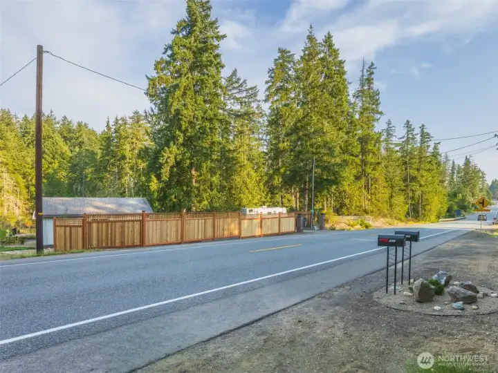 View of both of the parcels entrances from Grapeview Loop Road. Waterfront home on the left, vacant land on the right