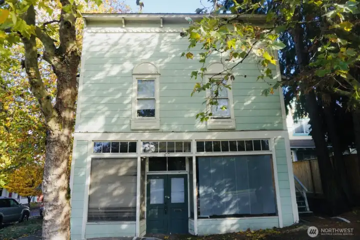 Large picture windows and a double door entry anchor the façade, while upper windows add charm and character—offering a beautiful street view from the second floor.