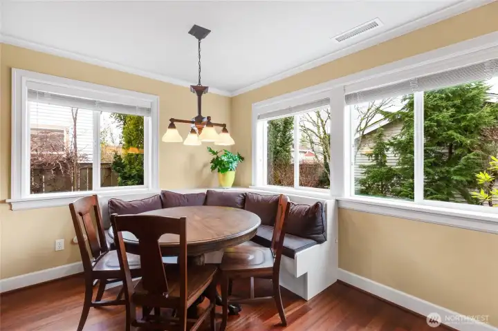 Dining room has a built-in bench and looks over the serene landscape outside.