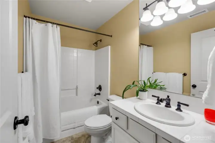 Main bathroom upstairs with bathtub and shower.