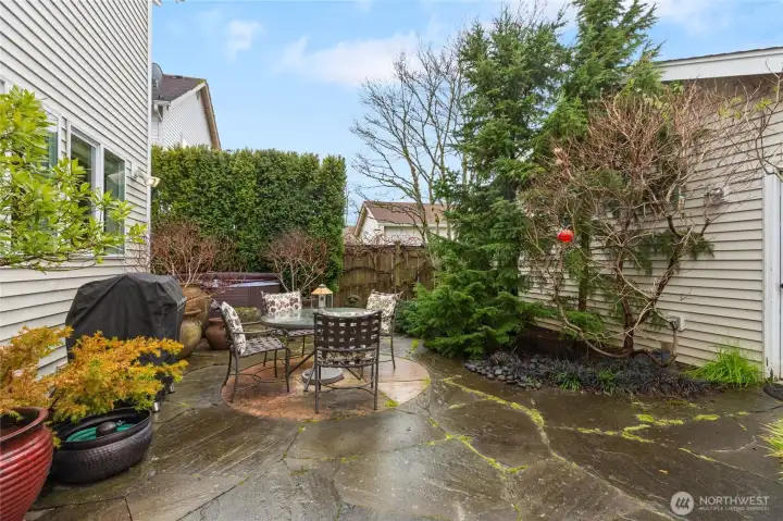 Bluestone patio, hot tub and water feature enhance the fenced back yard.