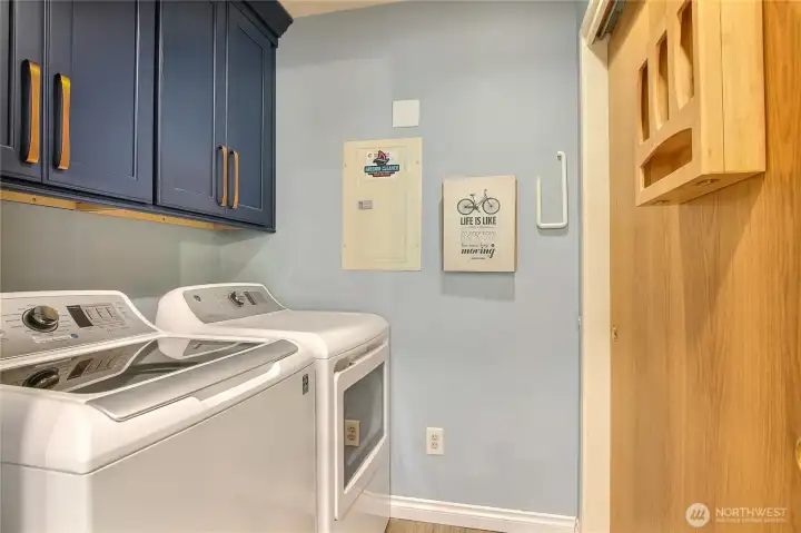 Walk-in laundry. Side-by-side washer/dryer with cabinets above.