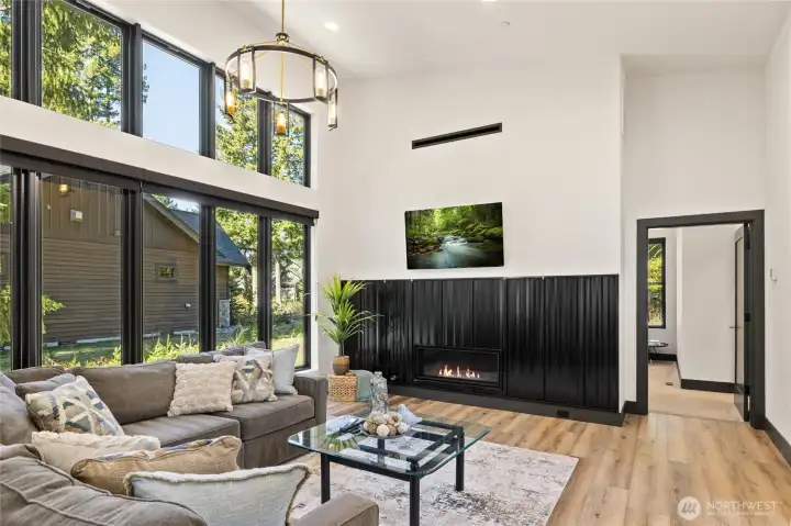 Brass and iron lighting & chandelier fixtures, paired with an industrial-style fireplace, bring a distinctive character to the living room.