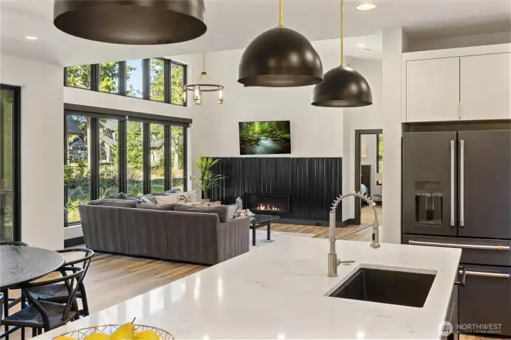 Quartz countertops on the eating island are beautifully highlighted by perfectly placed dome pendant lighting.