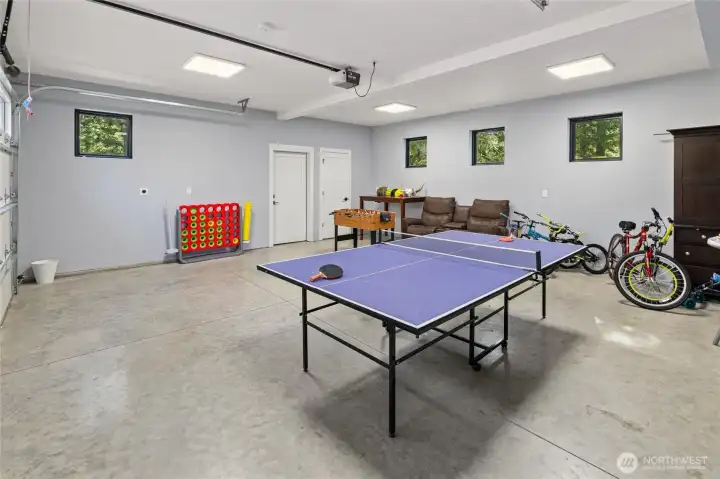 This home features a large garage that is currently creatively utilized as an inviting and fun-filled game room, perfect for family entertainment and leisure activities.