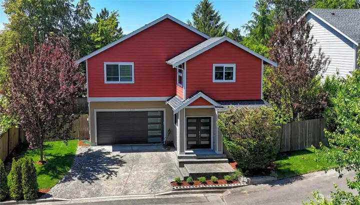 Modern two-story home featuring a spacious driveway, attached garage, and private fenced setting.
