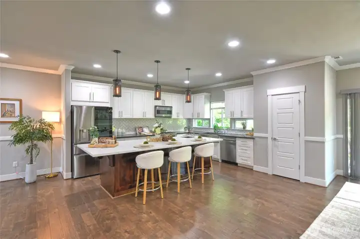 Gourmet kitchen with oversized island, pendant lighting, and abundant cabinetry.