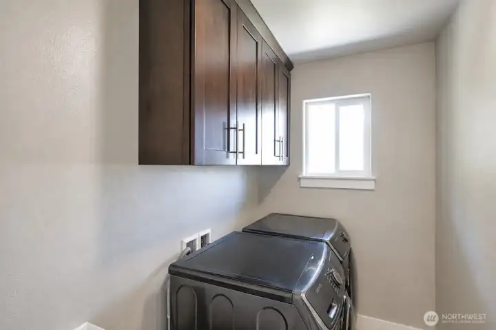 Upstairs laundry room with built-in cabinetry and storage. Upstairs laundry room with built-in cabinetry and storage.