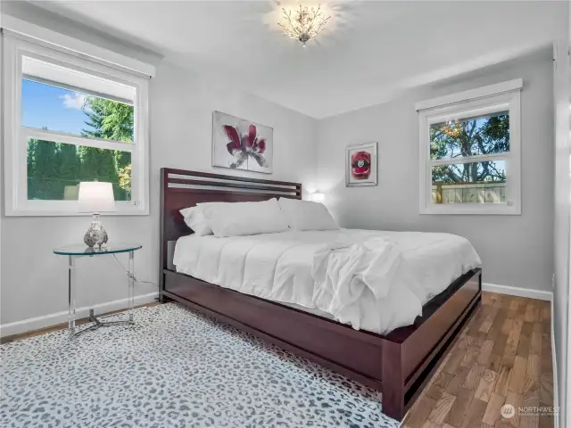 The primary bedroom is roomy and has a tranquil atmosphere. The space allows for different configurations of how to furnish it and allows you to make it your own retreat.