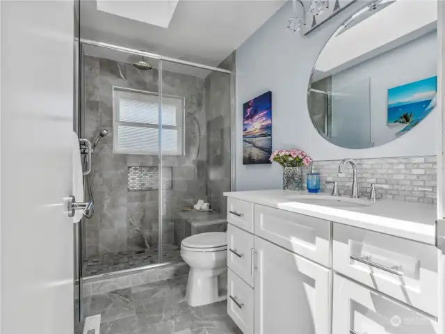 The bathroom is: "light and bright". The walk-in shower with custom tile brings a luxurious feel to this beautiful space.