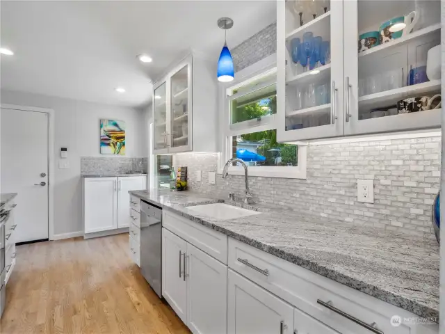 The efficient galley kitchen features granite countertops and custom tile backsplash. The glassed cabinets allows you to display you favorit dishes and glass ware.