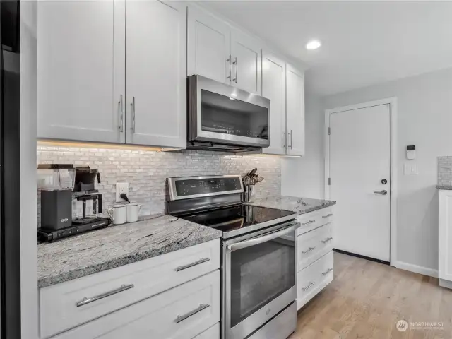 White kitchen, granite countertops and stainless steel appliances is a classic look that does not disappoint.