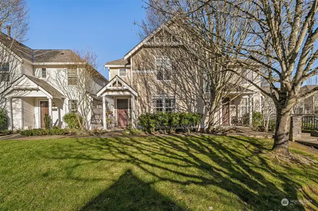 Front of townhouse with large grassy area in front.