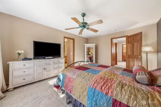 Primary bedroom with ceiling fan and space for furnishings.