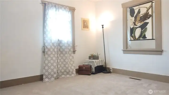 bedroom has two closets which the second one is movable.  This is staged.  Owner has is going to have the hardwood floors showing soon or a buyer can ask for a different color carpet to brighten up this back bedroom that has a window AC unit