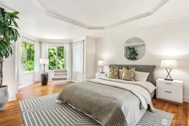 The primary bedroom is a true luxurious retreat with a sitting area and serene views of the backyard.
