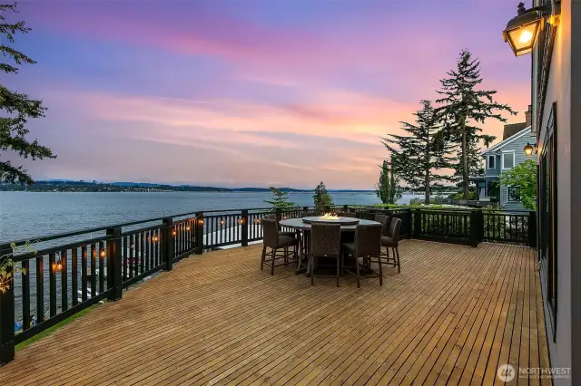 Expansive deck seen at twilight just off the kitchen and dining areas