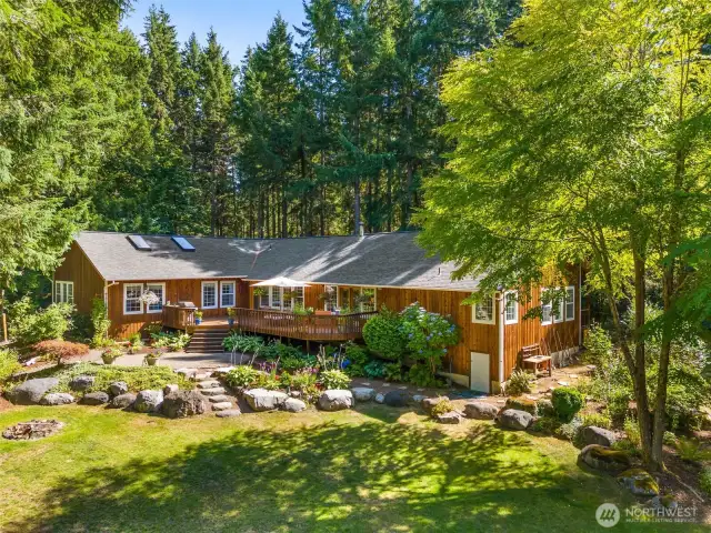 What a beautiful setting. Perennial beds and rock hardscape. Fire pit, and sunny lawn is a good balance with the wooded trails. Very private setting.