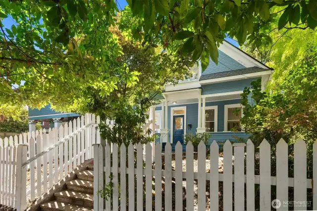 A new white picket fence defines the garden, dotted with glorious mature trees and seasonal perennials.