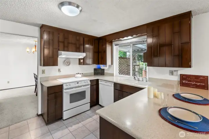 Updated over the years, the kitchen offers great countertop space for meal prep and appliances are included. The window looks out over the fully fenced rear yard.