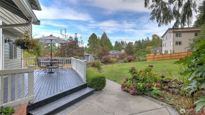 Outdoor living space overlooking landscaped grounds and mature trees.