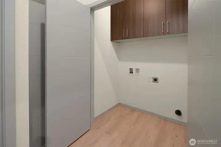 Dedicated laundry room with built-in storage cabinets and plenty of workspace.