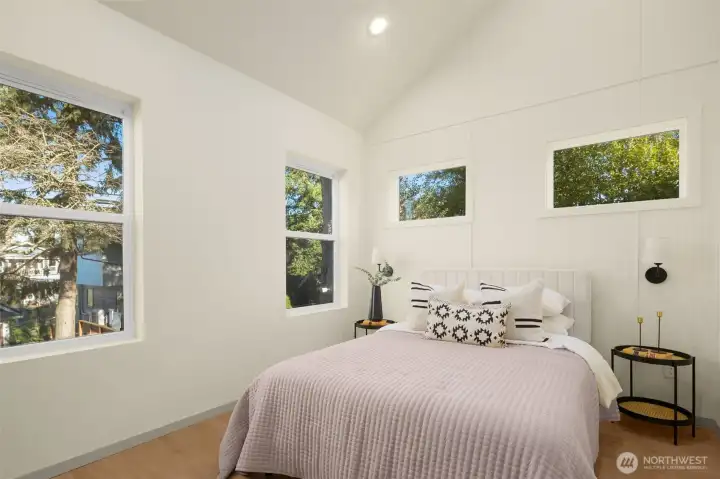 Bright and airy primary bedroom featuring large windows and clean modern lines.