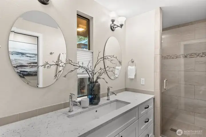 Dual faucets and mirrors and ample storage in this updated primary bath.