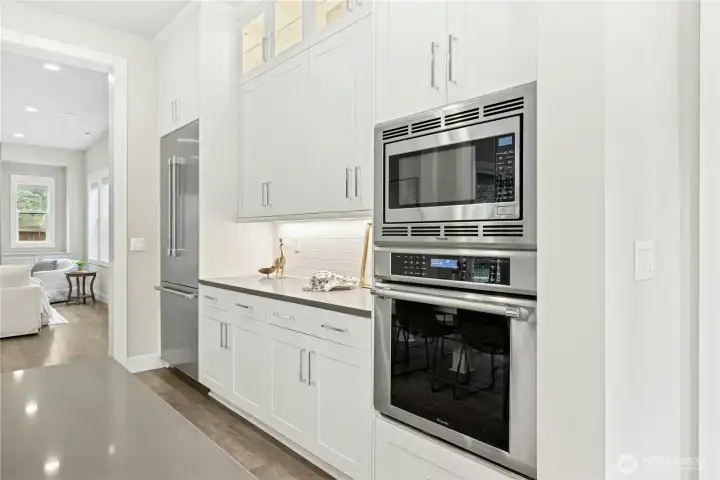 Built-in Thermador double ovens and microwave are seamlessly integrated into custom cabinetry, offering both high-performance cooking and streamlined design. Extensive storage, under-cabinet lighting, and sleek finishes enhance the kitchen’s functionality while maintaining its clean, modern aesthetic.