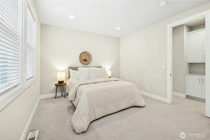 The second secondary bedroom offers a comfortable layout with soft carpeting and recessed lighting, creating a calm and inviting atmosphere.