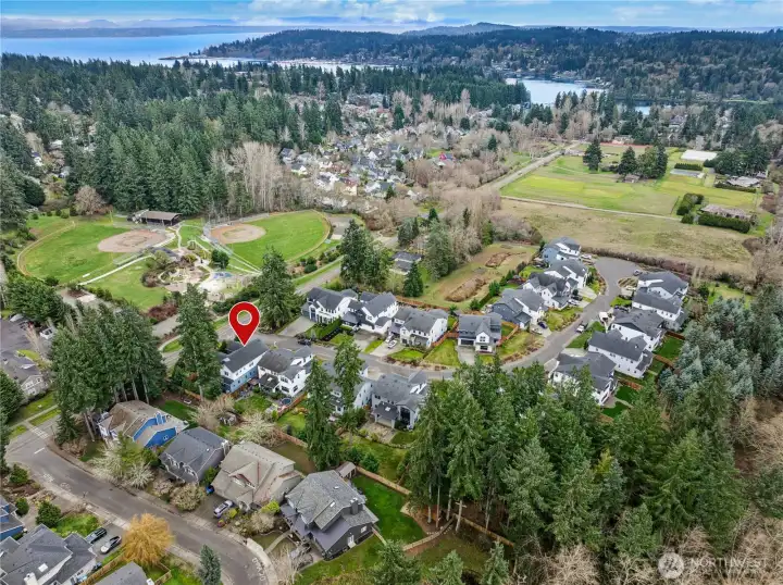 Elevated aerial view showcasing the home’s proximity to Rotary Park and the surrounding neighborhood. Eagle Harbor shimmers in the distance, highlighting the island setting and natural beauty that define Bainbridge living.
