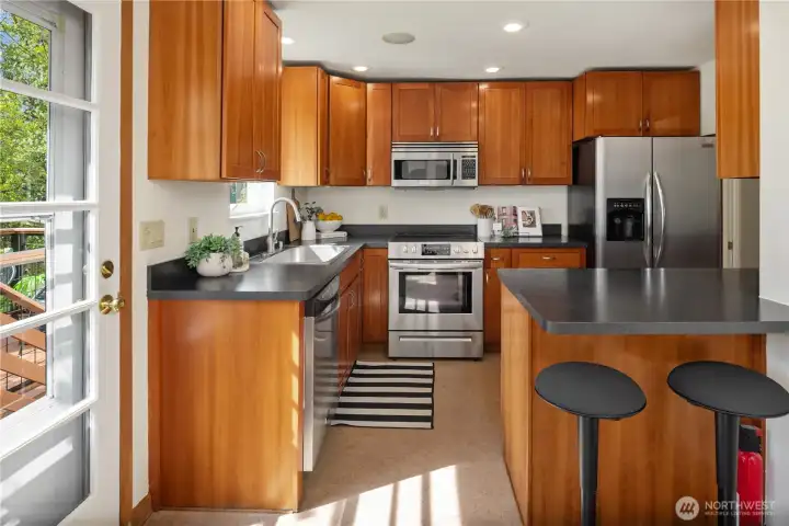 This gorgeous kitchen has full-height upper cabinets, cherry wood cabinets and is fully equipped with Stainless appliances.